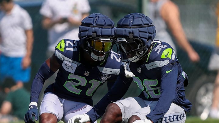 Seattle Seahawks cornerbacks Devon Witherspoon (21) and Isas Waxter (36) run through a drill during a joint practice with the Green Bay Packers on Thursday, August 21, 2025, at Clarke Hinkle Field in Ashwaubenon, Wis. 