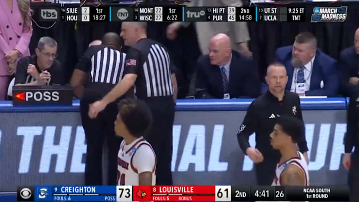 Referees discuss a technical foul called on Louisville head coach Pat Kelsey.