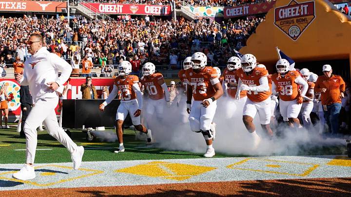 Texas Longhorns head coach Steve Sarkisian, Texas Longhorns wide receiver Parker Livingstone (13) and offensive lineman Brandon Baker (73) run onto the field before a game against the Michigan Wolverines at Camping World Stadium. Texas Longhorns head coach Steve Sarkisian, Texas Longhorns wide receiver Parker Livingstone (13) and offensive lineman Brandon Baker (73) run onto the field before a game against the Michigan Wolverines at Camping World Stadium.
