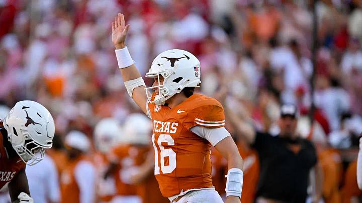 Texas Longhorns quarterback Arch Manning waves to the Oklahoma Sooners fans after he runs for a first down during the second half at the Cotton Bowl. Texas Longhorns quarterback Arch Manning waves to the Oklahoma Sooners fans after he runs for a first down during the second half at the Cotton Bowl.