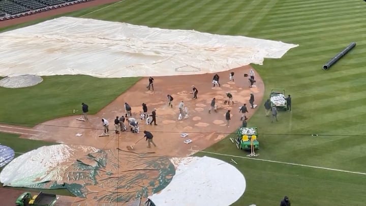 White Sox grounds crew tends to the infield during a rain delay at Rate Field. 