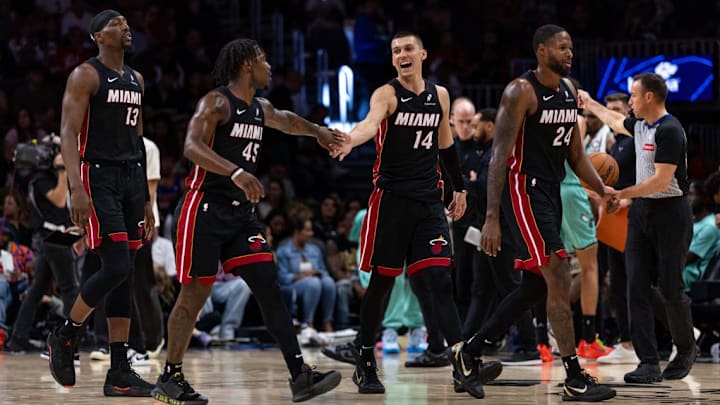 Miami Heat guard Tyler Herro (14) reacts with guard Davion Mitchell (45), Bam Adebayo (13) and Haywood Highsmith (24) the second half of an NBA game against the Charlotte Hornets at Kaseya Center on March 21, 2025, in Miami. 