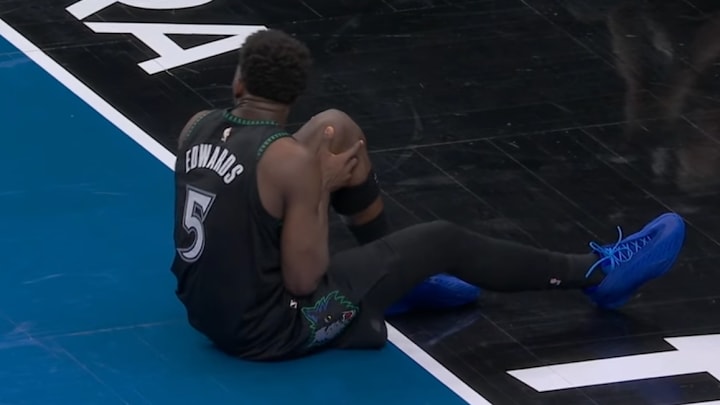 Anthony Edwards grabbing his left knee.