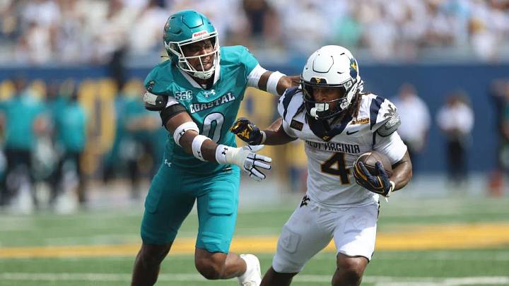 West Virginia's Cam Cook (4) breaks a tackle against Coastal Carolina's Chandavian Bradley (0) during an NCAA college football game in Morgantown, W.Va., Saturday, Sept. 5, 2026. (AP Photo/Gregory Payan) West Virginia's Cam Cook (4) breaks a tackle against Coastal Carolina's Chandavian Bradley (0) during an NCAA college football game in Morgantown, W.Va., Saturday, Sept. 5, 2026. (AP Photo/Gregory Payan)
