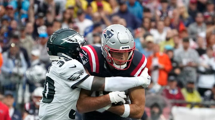 Justin Evans of the Eagles holds fast to Patriot receiver Hunter Henry after Henry pulls in a first