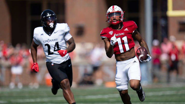 Miami Redhawks wide receiver Javon Tracy (11) runs downfield as Cincinnati Bearcats defensive end Darian Varner (24) defends in the first quarter of the College Football game at Yager Stadium in Cincinnati on Saturday, Sept. 14, 2024. Miami Redhawks wide receiver Javon Tracy (11) runs downfield as Cincinnati Bearcats defensive end Darian Varner (24) defends in the first quarter of the College Football game at Yager Stadium in Cincinnati on Saturday, Sept. 14, 2024.
