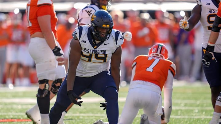 Oklahoma State Cowboys quarterback Alan Bowman (7) is sacked by West Virginia Mountaineers defensive lineman Hammond Russell IV (99).