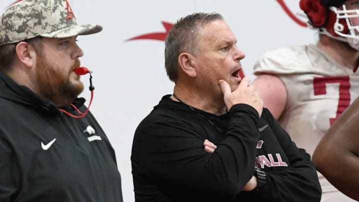 Arkansas coach Sam Pittman and offensive line coach Eric Mateos observe an April spring practice. CREDIT: Andy Hodges/allHOGS Media