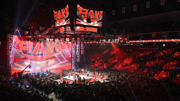 WWE Monday Night Raw in front of a packed crowd witnessing a match.