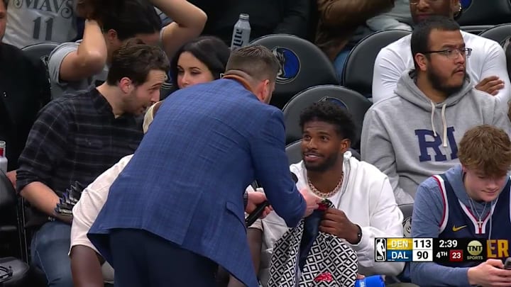 Jared Greenberg hands Greg Anthony's Jacket to Shedeur Sanders