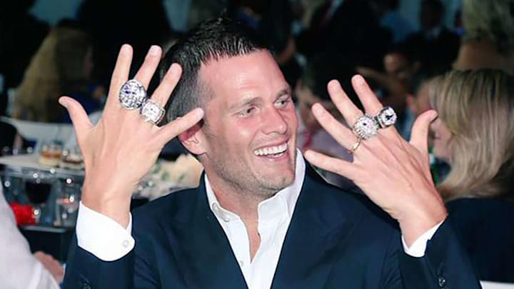 Tom Brady flashing 4 of his 7 Super Bowl rings