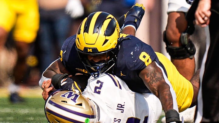 Michigan edge Derrick Moore (8) sacks Washington quarterback Demond Williams Jr. (2) during the first half at Michigan Stadium in Ann Arbor on Saturday, Oct. 18, 2025.