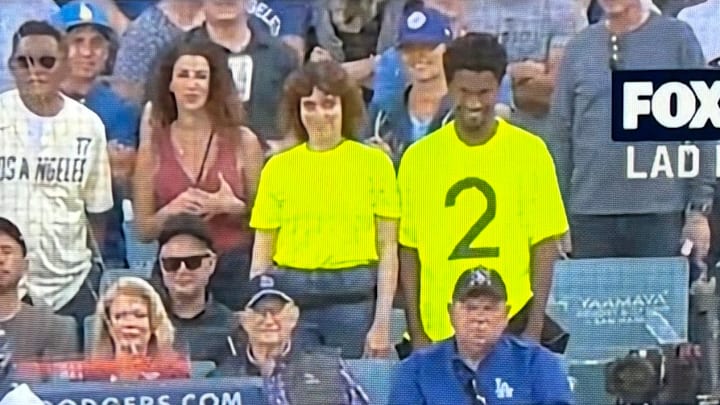 Two fans stand behind home plate at Game 2 of the NLCS between the Los Angeles Dodgers and New York Mets at Dodger Stadium, promoting the movie "Smile 2" on Monday, October 14, 2024. Two fans stand behind home plate at Game 2 of the NLCS between the Los Angeles Dodgers and New York Mets at Dodger Stadium, promoting the movie "Smile 2" on Monday, October 14, 2024.