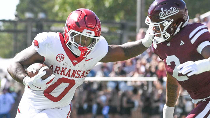 Arkansas Razorbacks running back Braylen Russell (0) stiff-arms Mississippi State Bulldogs safety Isaac Smith (2) during the first quarter at Davis Wade Stadium at Scott Field.