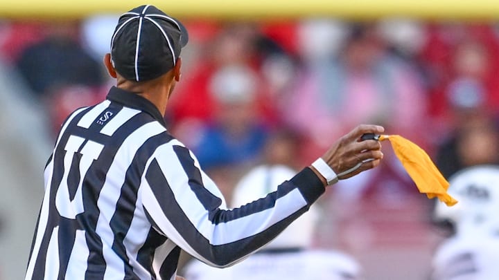 An official prepares to throw a flag in the Arkansas Razorbacks game against the Mississippi State Bulldogs at Razorback Stadium in Fayetteville, Ark.
