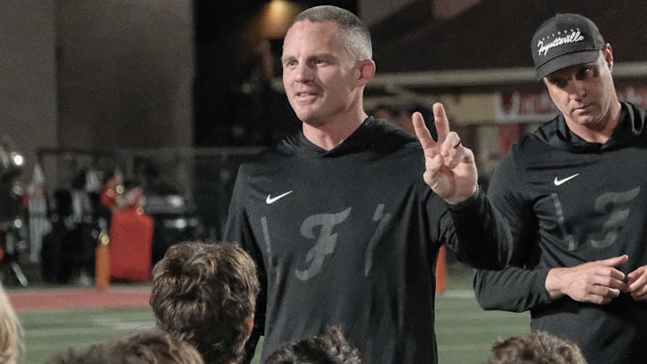 Fayetteville Bulldogs coach Casey Dick addressing his team after game with Fort Smith Northside Grizzlies.