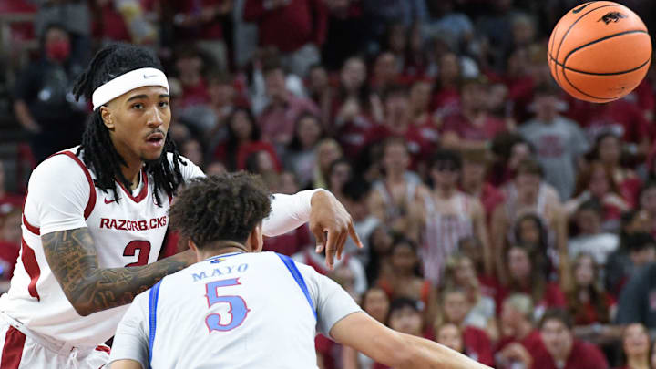 Arkansas Razorbacks guard Boogie Fland makes a pass defended by Kansas Jayhawks Zeke Mayo at Bud Walton Arena in Fayetteville, Ark.