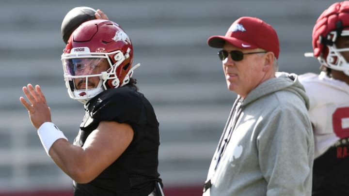 Arkansas Razorbacks quarterback Malachi Single throws a pass as offensive coordinator Bobby Petrino watches during Saturday morning's spring practice in warmups before a scrimmage at Razorback Stadium in Fayetteville, Ark.