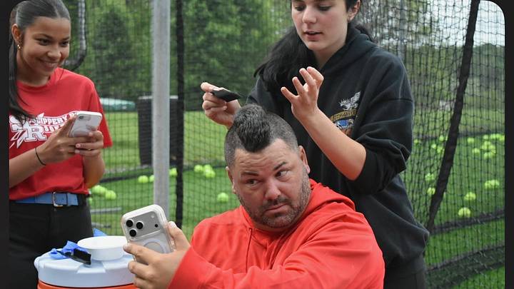 Slippery Rock softball coach Dan Beebe checks out his new mohawk. The second-year Rockets coach agreed to allow his hair to be shaved into a mohawk and be died red if Slippery Rock beat General McLane in the first round of the District 10 Class 4A playoffs. The Rockets won 8-7.