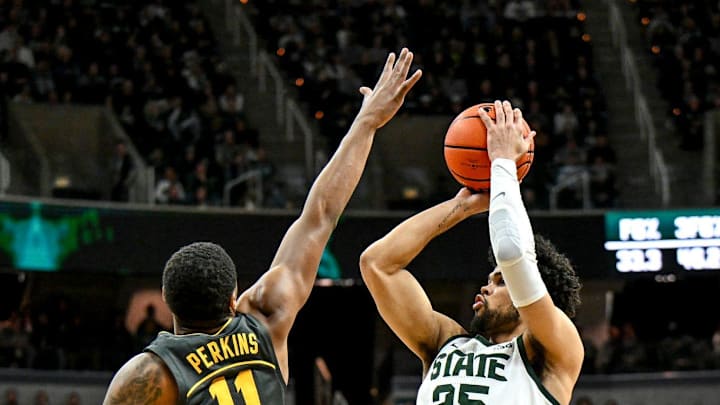 Michigan State's Malik Hall, right, scores as Iowa's Tony Perkins defends during the first half on