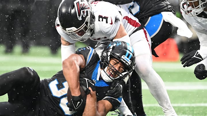 Dec 17, 2023; Charlotte, North Carolina, USA; Carolina Panthers running back Chuba Hubbard (30) is tackled by Atlanta Falcons safety Jessie Bates III (3) in the fourth quarter at Bank of America Stadium. 