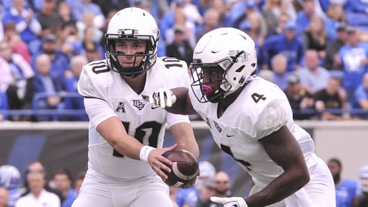 Oct 13, 2018; Memphis, TN, USA; UCF Knights quarterback McKenzie Milton (10) hands the ball off to UCF Knights running back Taj McGowan (4) during the first half against the Memphis Tigers at Liberty Bowl Memorial Stadium. Mandatory Credit: Justin Ford-Imagn Images