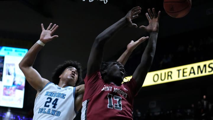 Rams forward David Fuchs and Hawk Rasheer Fleming watch as a rebound bounces out of their reach under the URI hoop. Rams forward David Fuchs and Hawk Rasheer Fleming watch as a rebound bounces out of their reach under the URI hoop.