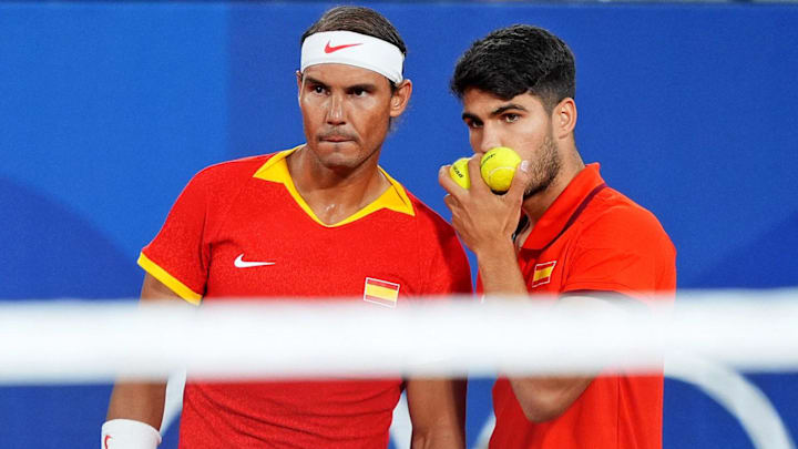 Jul 28, 2024; Paris, France; Rafal Nadal (ESP) and Carlos Alcaraz (ESP) talk during their match against Maximo Gonzales (ARG) and Andres Molteni (ARG) in the men's tennis doubles first round during the Paris 2024 Olympic Summer Games at Stade Roland Garros. Jul 28, 2024; Paris, France; Rafal Nadal (ESP) and Carlos Alcaraz (ESP) talk during their match against Maximo Gonzales (ARG) and Andres Molteni (ARG) in the men's tennis doubles first round during the Paris 2024 Olympic Summer Games at Stade Roland Garros.