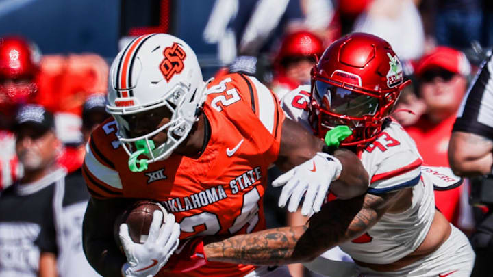 Oct 4, 2025; Tucson, Arizona, USA; Arizona Wildcats defensive back Dalton Johnson (43) tackles Oklahoma State Cowboys running back Trent Howland (24) during the second quarter at Arizona Stadium. Mandatory Credit: Aryanna Frank-Imagn Images Oct 4, 2025; Tucson, Arizona, USA; Arizona Wildcats defensive back Dalton Johnson (43) tackles Oklahoma State Cowboys running back Trent Howland (24) during the second quarter at Arizona Stadium. Mandatory Credit: Aryanna Frank-Imagn Images