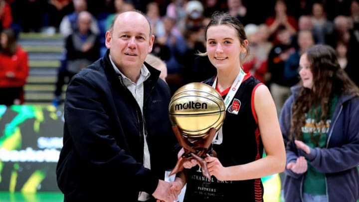 Virginia College’s Emma Tolan is presented with the MVP award by Basketball Ireland President PJ Reidy.