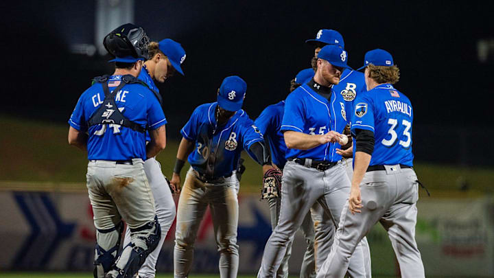 Biloxi Shuckers’ Shane Smith (35) hands the ball to Joe Ayrault (33) to pitch against the Mississippi Braves at Trustmark Park in Pearl, Miss., on the Brave’s opening day, Tuesday, April 9, 2024. Braves won 2-0 after the game was called in the top of the eighth inning due to a tornado warning.