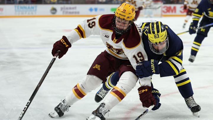 Gophers forward John Mittelstadt fighting for the puck against Michigan.