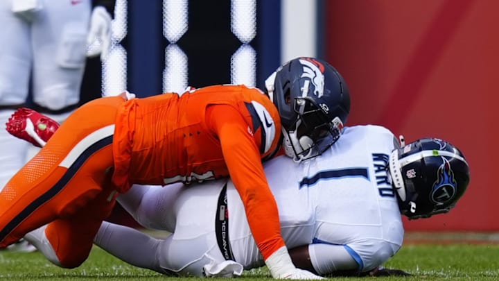 Sep 7, 2025; Denver, Colorado, USA; Denver Broncos linebacker Nik Bonitto (15) sacks Tennessee Titans quarterback Cam Ward (1) in the first half at Empower Field at Mile High. Mandatory Credit: Ron Chenoy-Imagn Images