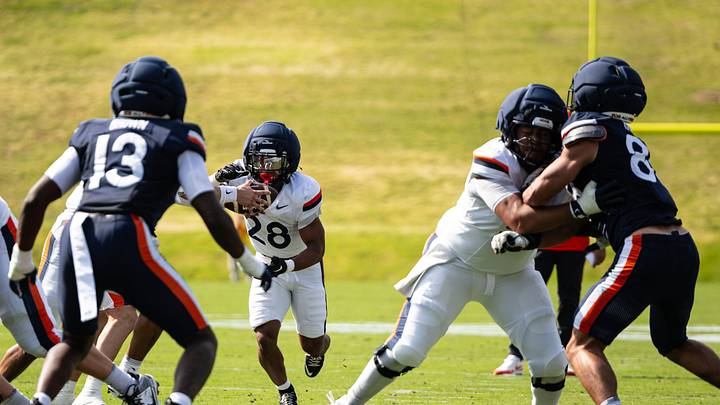 Running back Solomon Beebe (28) runs the ball as linebacker Myles Brown (13) defends at Virginia's Spring Game, April 16. Running back Solomon Beebe (28) runs the ball as linebacker Myles Brown (13) defends at Virginia's Spring Game, April 16.