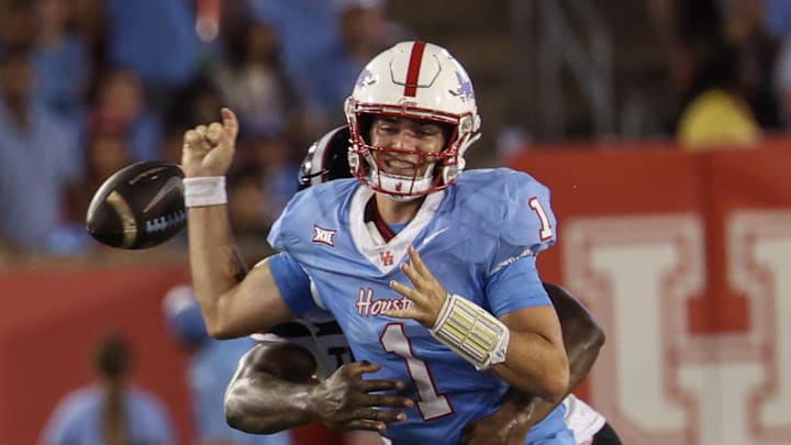Oct 4, 2025; Houston, Texas, USA;Houston Cougars quarterback Conner Weigman (1) fumbles the ball as he is hit by Texas Tech Red Raiders linebacker David Bailey (31) in the first half at TDECU Stadium. Mandatory Credit: Thomas Shea-Imagn Images