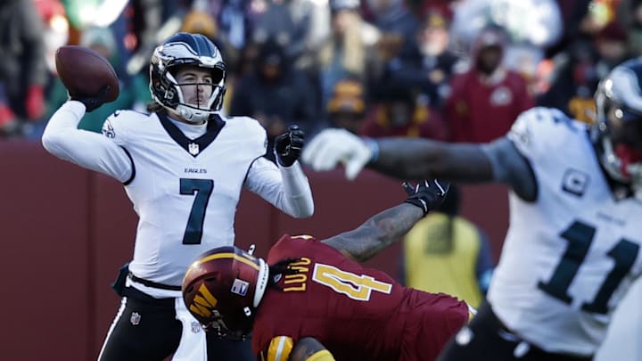 Dec 22, 2024; Landover, Maryland, USA; Philadelphia Eagles quarterback Kenny Pickett (7) passes the ball as Washington Commanders linebacker Frankie Luvu (4) defends during the second quarter at Northwest Stadium. Mandatory Credit: Geoff Burke-Imagn Images