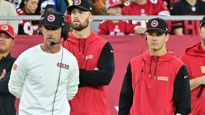 Jan 5, 2025; Glendale, Arizona, USA;  San Francisco 49ers quarterback Brock Purdy (right) and head coach Kyle Shanahan (left) look on the in second half against the Arizona Cardinals at State Farm Stadium. Mandatory Credit: Matt Kartozian-Imagn Images