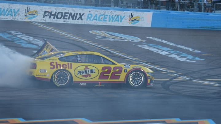 Joey Logano performs a celebratory burnout after winning the 2024 NASCAR Cup Series Championship Race at Phoenix Raceway to become a three-time NASCAR Cup Series champion.