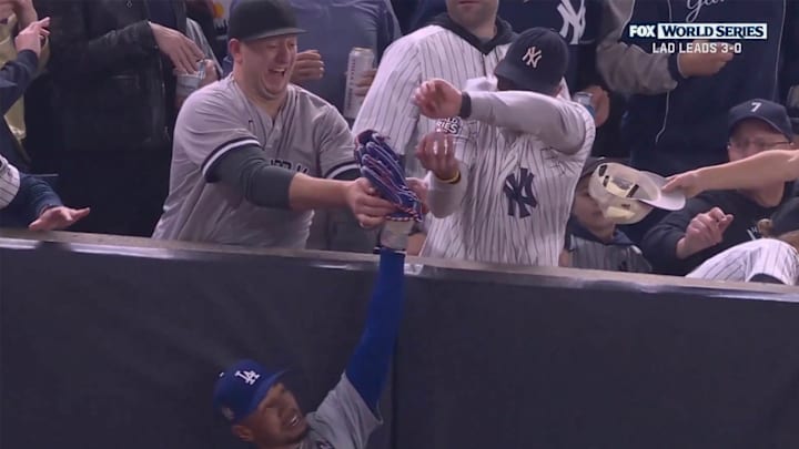 A Yankees fan attempted to pry a fly ball out of Mookie Betts's glove in the first inning of Game 4.