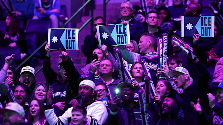 Fans hold signs to protest the presence of federal agents in Minneapolis prior to the start of the third quarter at Target Center.