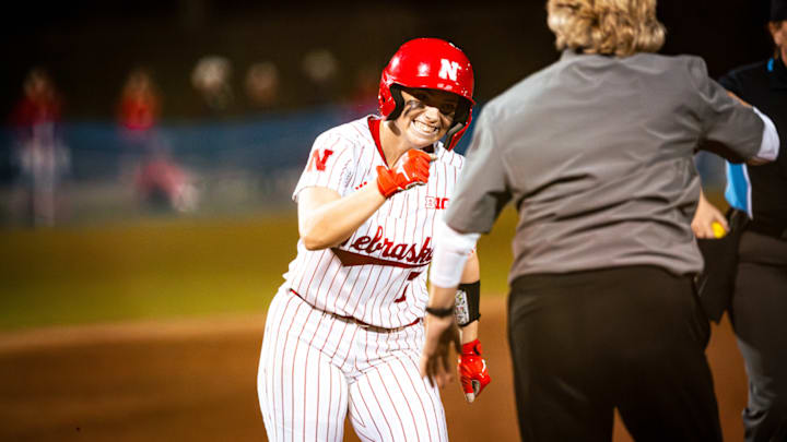Nebraska softball's Ava Kuszak rounds third and fist bumps head coach Rhonda Revelle after hitting a home run against Bethune-Cookman.