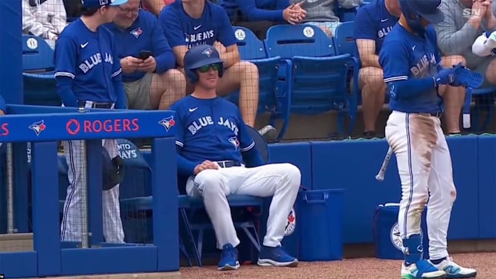 Chris Bassitt sits near the dugout, preparing for his duties as the Blue Jays' ball boy.