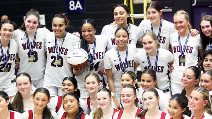 The Tualatin girls basketball players and cheerleaders gather after the Timberwolves’ victory in Saturday’s Class 6A state championship game.