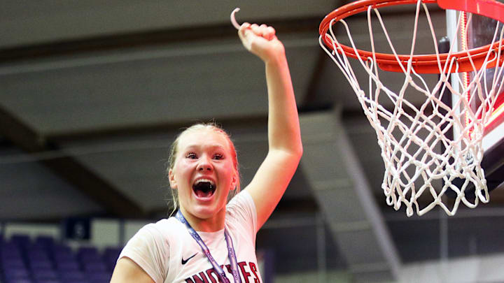 Tualatin junior Ries Miadich cuts part of the net after the Timberwolves’ 63-58 win over Clackamas in the Class 6A state championship game.