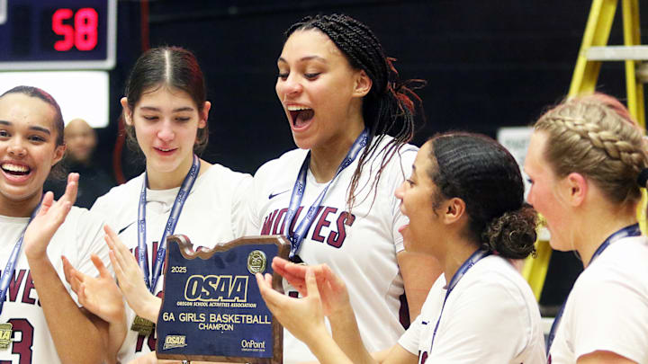 Tualatin senior Jordyn Smith smiles as she holds the state championship trophy after the Timberwolves’ 63-58 win over Clackamas in Saturday’s 6A title game.