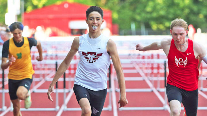 Tualatin High School freshman Brock Estes sticks his tongue out as he crosses the finish line in first place in the 110-meter high hurdles race at the Three Rivers League district track and field championships.