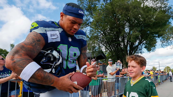 Seattle Seahawks tight end Elijah Arroyo (18) signs an autograph for a fan on his way to a joint practice with the Green Bay Packers on Thursday, August 21, 2025, at Lambeau Field in Green Bay, Wis. 