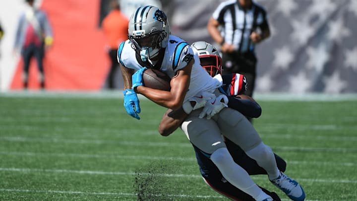 Sep 28, 2025; Foxborough, Massachusetts, USA; New England Patriots safety Jaylinn Hawkins (21) tackles Carolina Panthers wide receiver Tetairoa McMillan (4) during the first half at Gillette Stadium. 