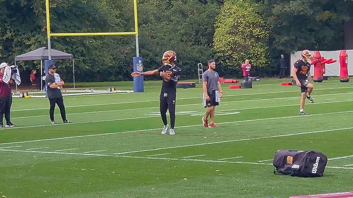 Washington Commanders quarterback Jayden Daniels gets ready to practice wearing an elbow brace.