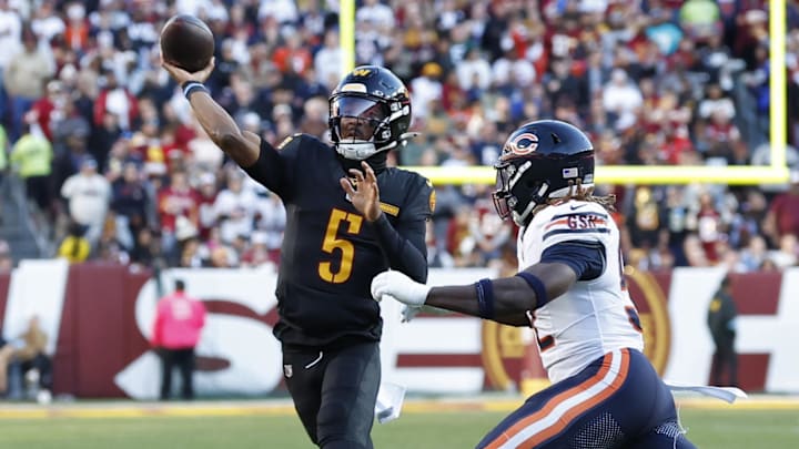 Oct 27, 2024; Landover, Maryland, USA; Washington Commanders quarterback Jayden Daniels (5) passes the ball as Chicago Bears defensive end Darrell Taylor (52) chases during the first quarter at Northwest Stadium.